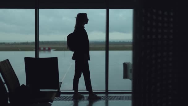 Silhouetten van een jonge vrouw op de luchthaven. — Stockvideo