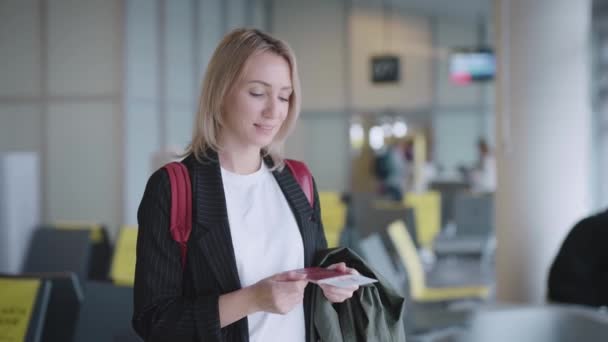 空港で魅力的な若い女性が出発を待っている。書類 — ストック動画