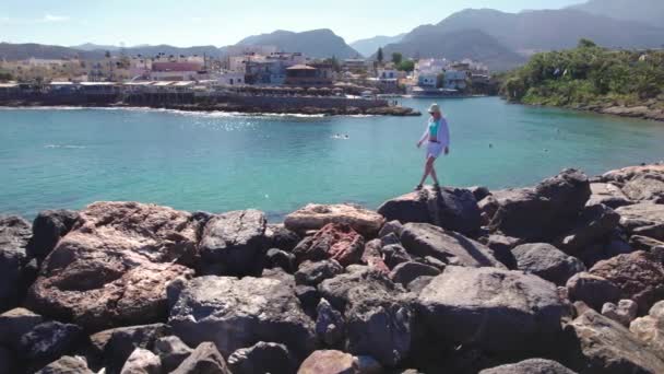 Młoda kobieta spacerująca po falochronach, letnie wakacje i sezon turystyczny w Grecji. — Wideo stockowe