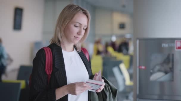 Приваблива молода жінка в аеропорту чекає свого від'їзду. Документи — стокове відео