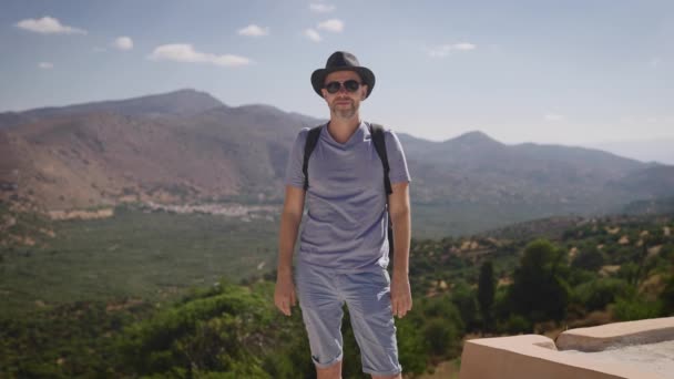 Happy tourist with a backpack enjoying a beautiful view of the valley and mountains. Summer — Stock Video