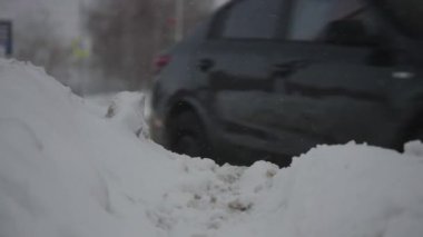 Şiddetli kar yağışı sırasında şehir yolları. Arabalar kış çamurunda ve karda yol alır.