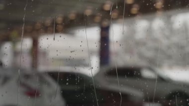 Islak alışveriş merkezi pencereleri. Camdan şehri görebilirsin.