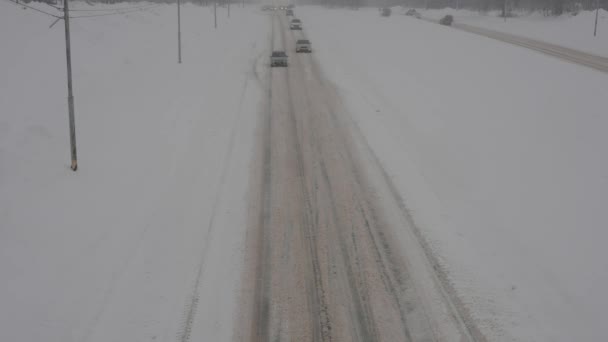 Las carreteras de la ciudad durante fuertes nevadas. Coches conducen a través de barro invierno y nieve — Vídeos de Stock