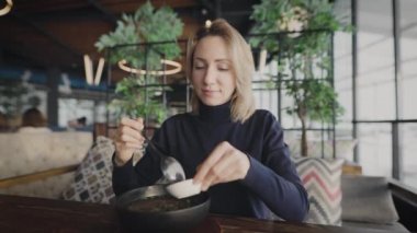 Restoranda çekici bir sarışın. Bir kadın pan-Asya çorbası içiyor..