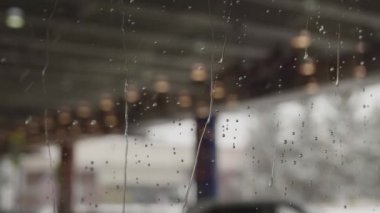 Islak alışveriş merkezi pencereleri. Camdan şehri görebilirsin.