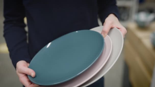 Obchod s potřebami pro domácnost a kuchyňské nádobí. Dámské ruce drží talíře. — Stock video