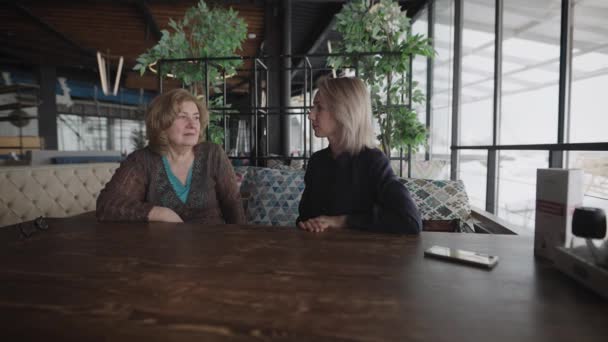 Młode i stare kobiety w restauracji. Matka i córka spotkały się na rozmowach i plotkach.. — Wideo stockowe