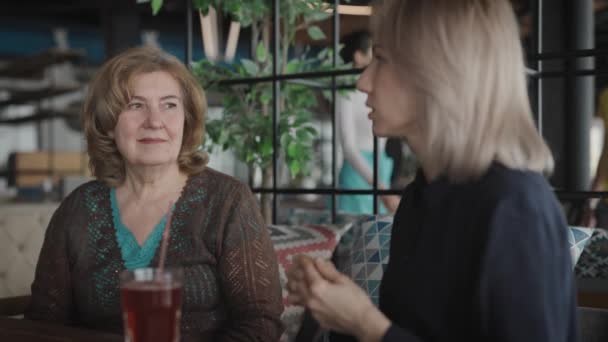 Donne giovani e anziane in un ristorante. Madre e figlia incontrate per la comunicazione e pettegolezzi. — Video Stock