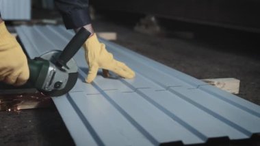 Üretim işçisi. Adamın biri öğütücüyle metal bir levhayı kesiyor.