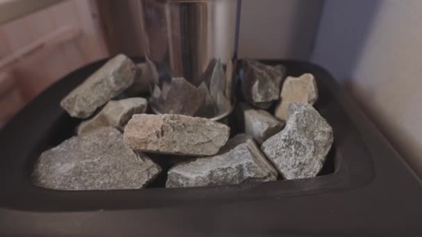 El agua se salpica sobre piedras calientes para generar vapor en la sauna. — Vídeo de stock