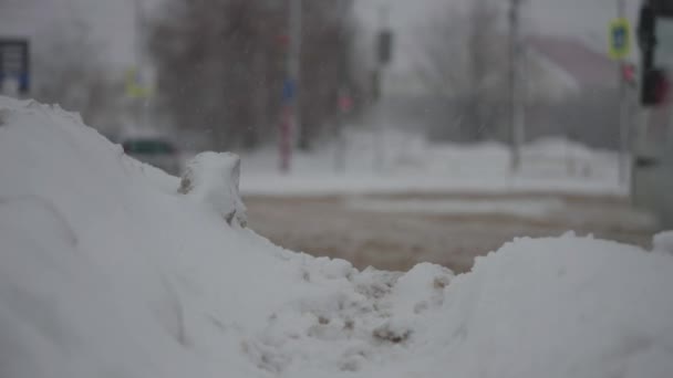 Міські дороги під час сильних снігопадів. Автомобілі проїжджають через зимовий бруд і сніг — стокове відео