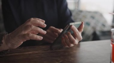 Genç ve yaşlı kadınların elleri. Anne ve kızı akıllı telefon kullanıyor..