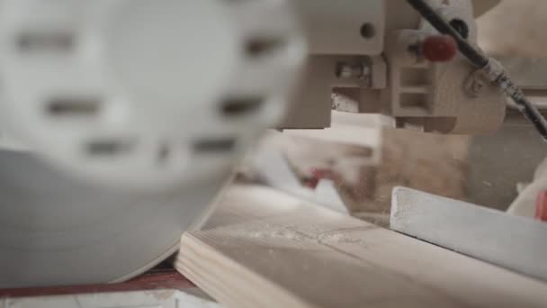 En el taller de carpintería. Un trabajador corta una tabla con una sierra de inglete. — Vídeos de Stock