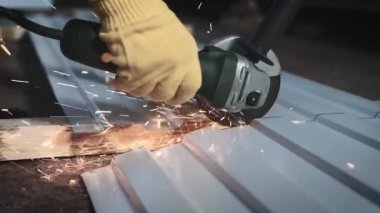 Üretim işçisi. Adamın biri öğütücüyle metal bir levhayı kesiyor.