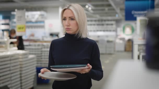Fiatal nő egy konyhai boltban. Női kézfogás tányérok. — Stock videók