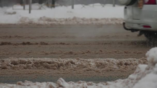 Byveier under kraftig snøfall. Biler kjører gjennom vintermudder og snø – stockvideo