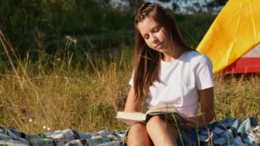 Küçük tatlı bir kız yaz kampında kitap okuyor.. 