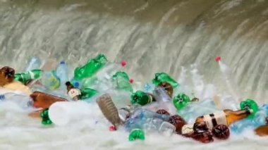 Kirlenmiş nehir suyundaki plastik şişeler. Ekoloji sorunları ve yok olma tehditleri.