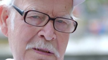 Yaşlı üzgün adam kameraya bakıyor. Emeklinin canı sıkkın 