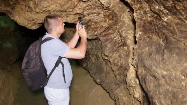 Jovem cientista turístico estuda o estado da caverna. — Vídeo de Stock