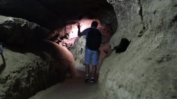 Young tourist scientist studies the state of the cave. — Stock Video