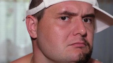 Yarı çıplak yüzlü genç bir adam, başını sallayarak dans ediyor.