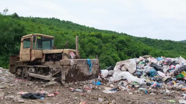 Um velho tractor está a descansar num aterro. O problema da reciclagem de resíduos. — Vídeo de Stock
