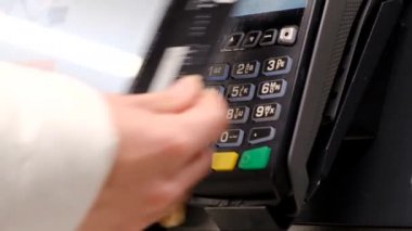 Terminalin önünde kredi kartıyla ödeme. Görüntü olmayan siyah kredi kartı.. 