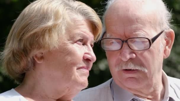 Portrait d'un couple d'âge mûr coûteux assis sur un banc de parc. — Video