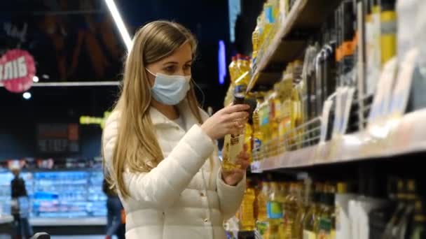 美しいヨーロッパの女の子は、ハイパーマーケットで植物油を取ります. — ストック動画