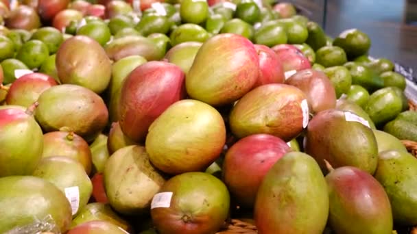 Een vrouwenhand plukt rijpe sappige mango 's in de supermarkt — Stockvideo