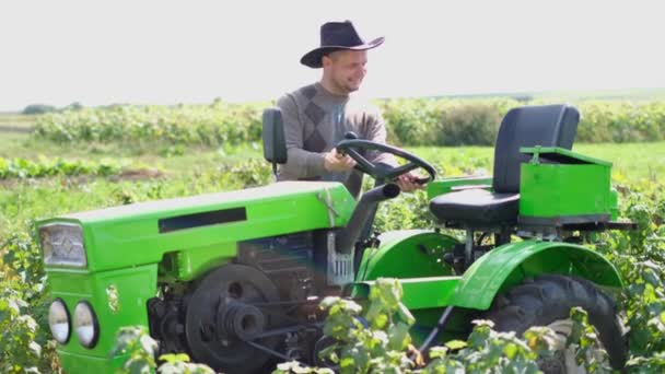 Een gelukkige boer houdt van zijn tractor, hij danst ernaast. Dorpsman dansend in het veld. — Stockvideo