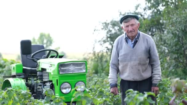 Starý unavený dědeček stojí na svém poli na venkově. — Stock video