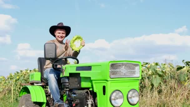 Gelukkig boer lacht terwijl zitten op zijn groene trekker — Stockvideo