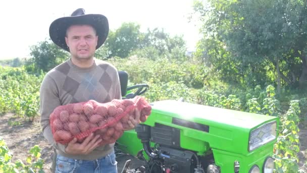 Karismatisk äldre jordbrukare som innehar en påse potatis. — Stockvideo