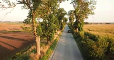 Güzel bir SUV gün batımında asfalt bir yolda gidiyor.. 