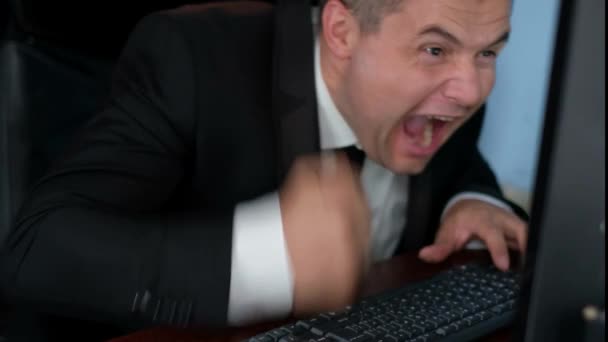 Wściekły biznesmen łamie laptopa rękami — Wideo stockowe
