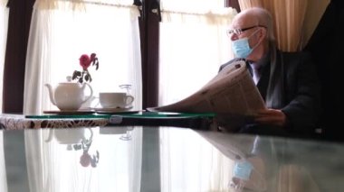 Yaşlı büyükbaba bir kafede oturmuş gazete okuyor..