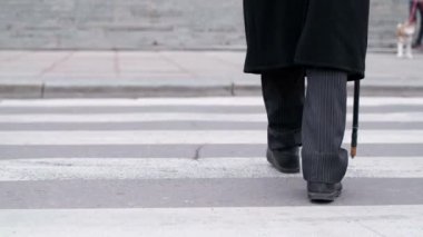 Bir adam sopayla caddeyi geçiyor..