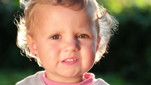 유럽의 작은 어린이의 아름다운 얼굴, 해 가 머리에 빛을 비춘다. — 비디오