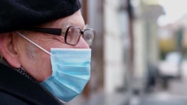 Yaşlı büyükbaba koronavirüse karşı koruyucu bir maske takıyor.. 