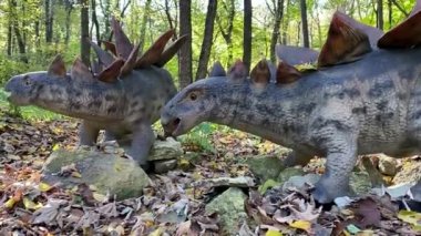 Çocuklar dinozor heykelleriyle park ederler.. 