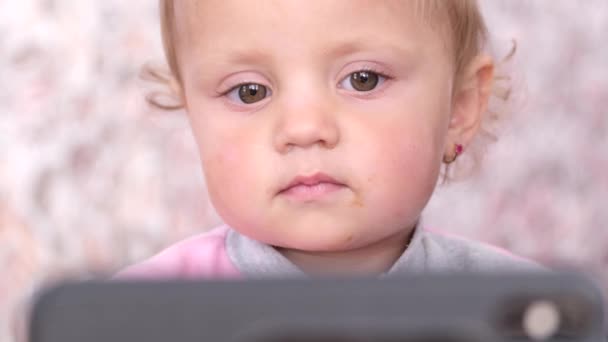 Piccola bella ragazza guardando un cartone animato dal telefono. — Video Stock