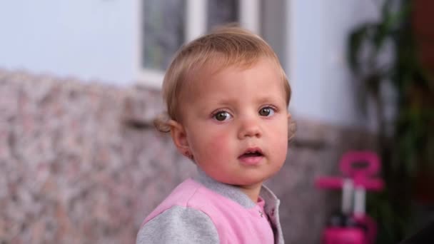 Vackert babyansikte tittar in i kameralinsen. — Stockvideo