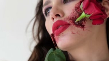 Ağzında gül olan güzel bir kız. Alışılmadık makyaj.