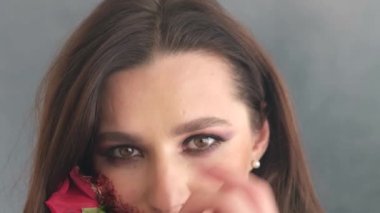 Beyaz duman içinde güzel bir esmer. Kanla makyaj yaptı ve ağzına güldü.. 