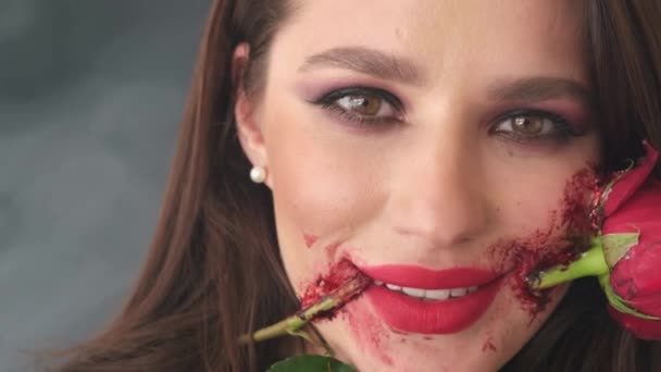 Flicka med blod och ros i munnen, cool makeup för en fest. — Stockvideo