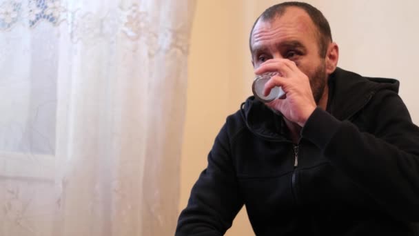 Homem triste e bebe vodka de um copo com dependência de álcool. — Vídeo de Stock