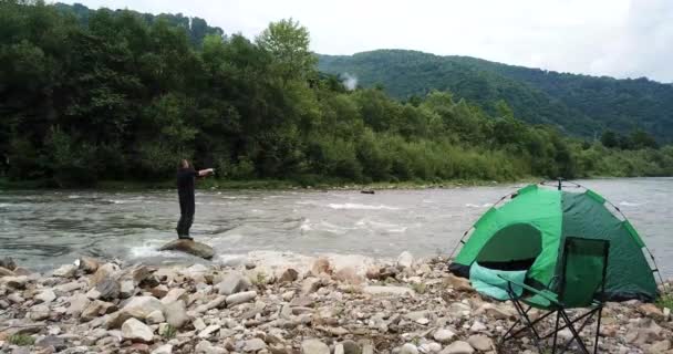 Pescador pega uma truta em um rio de montanha . — Vídeo de Stock